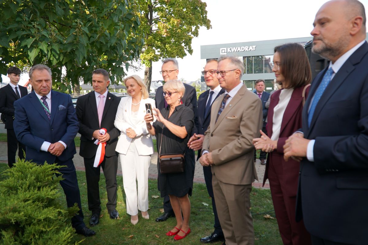 Zdjęcie przedstawia grupę osób stojących przed Zespołem Szkół Rolniczo-Technicznych w Zwoleniu.