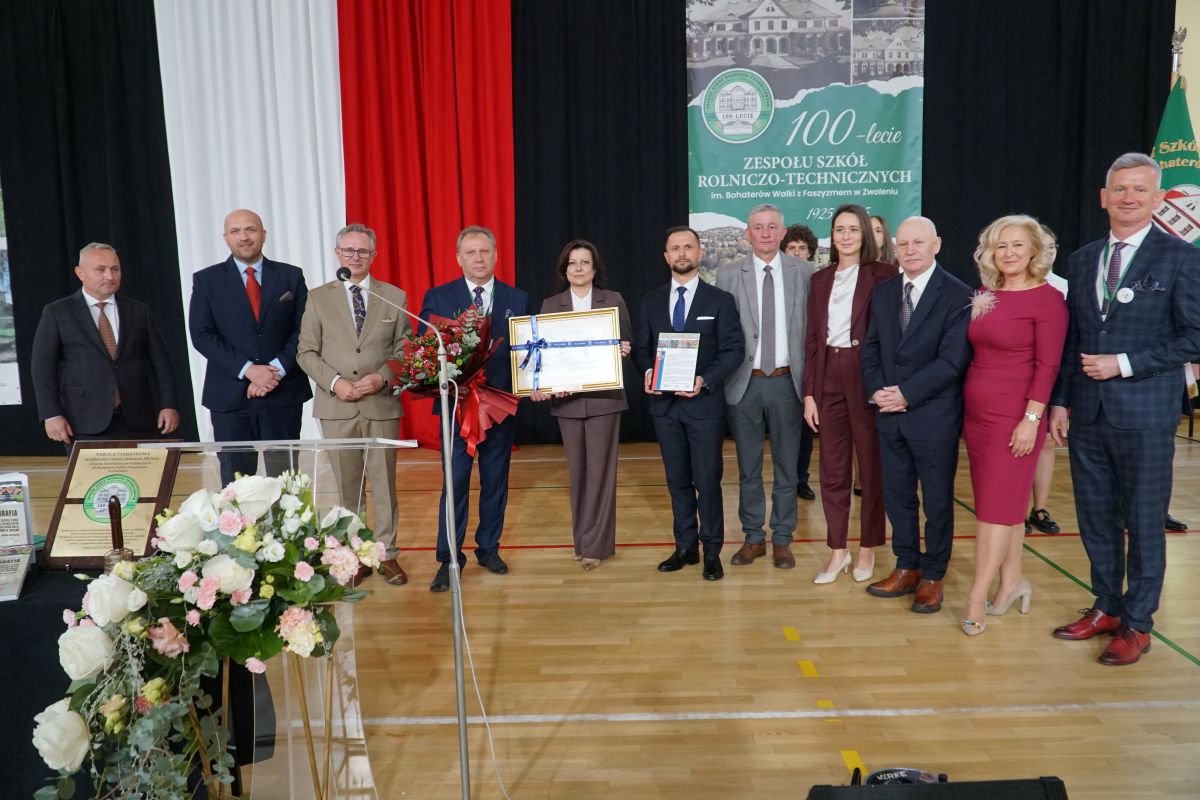 Zdjęcie przedstawia grupę osób stojących w hali sportowej Zespołu Szkół Rolniczo-Technicznych w Zwoleniu.
