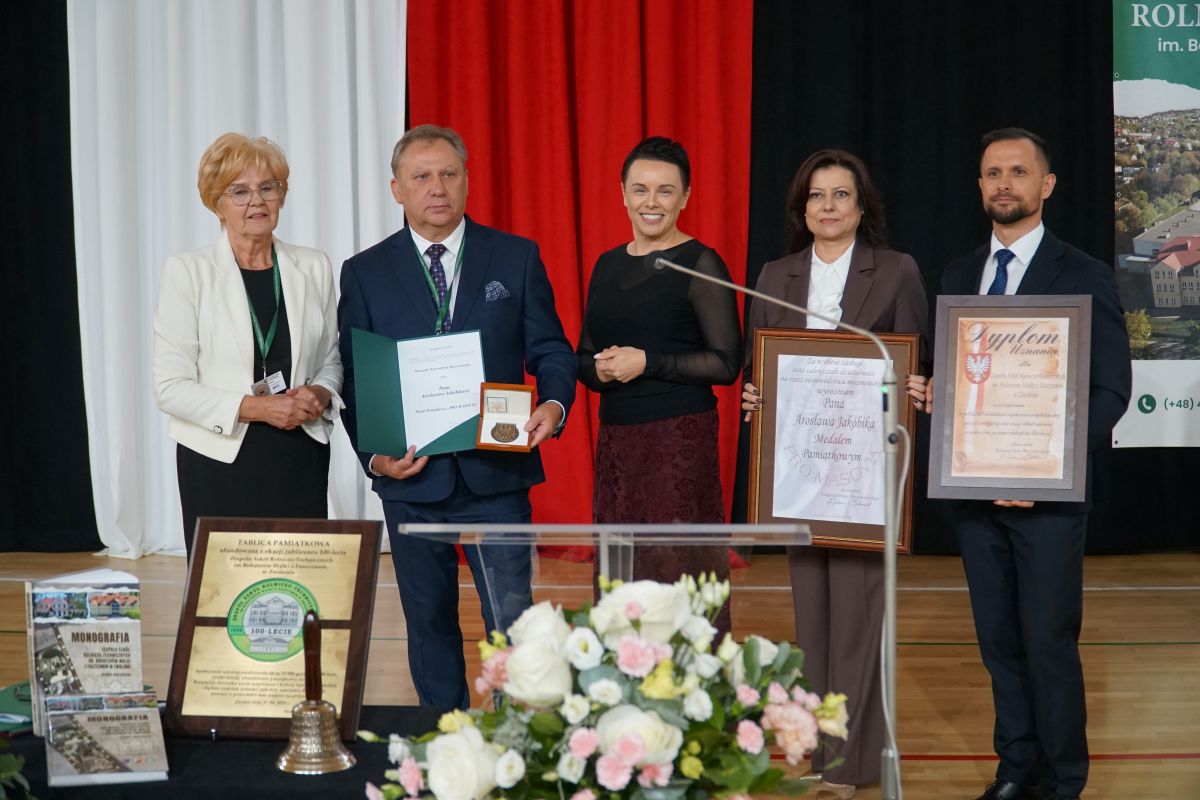 Zdjęcie przedstawia grupę osób z medalem 