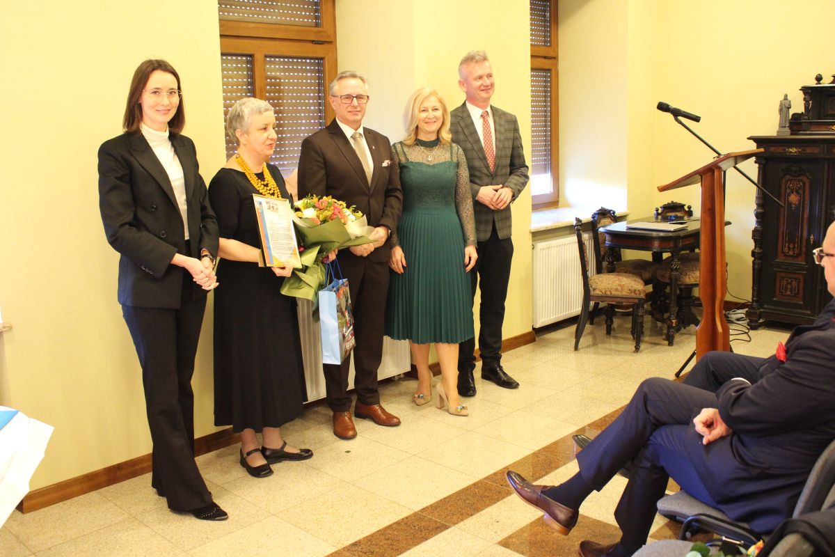 Zdjęcie przedstawia grupę osób stojących w muzeum regionalnym w Zwoleniu