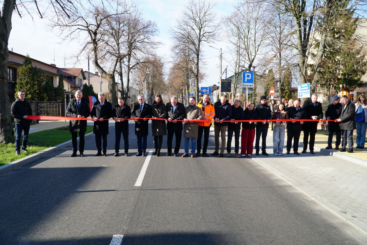 Zdjęcie przedstawia grupę os&oacute;b przecinających wstęgę na drodze powiatowej przy LO w Zwoleniu.