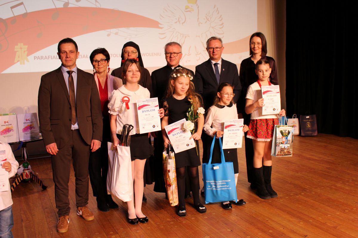 Zdjęcie przedstawia grupę os&oacute;b stojacych na scenie kina Świt podczas konkusu pieśni i poezji.