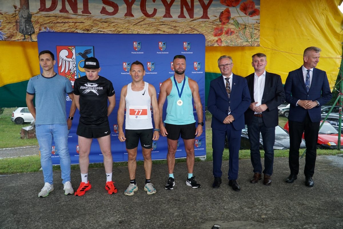 Zdjęcie przedstawia grupę os&oacute;b na scenie w Sycynie
