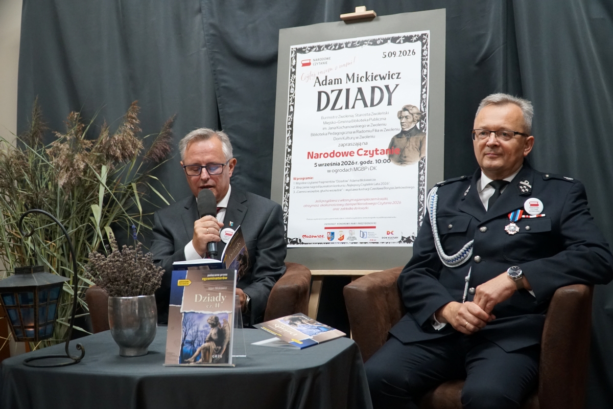 Zdjęcie przedstawia dw&oacute;ch mężczyzn czytających książkę w bibliotece.